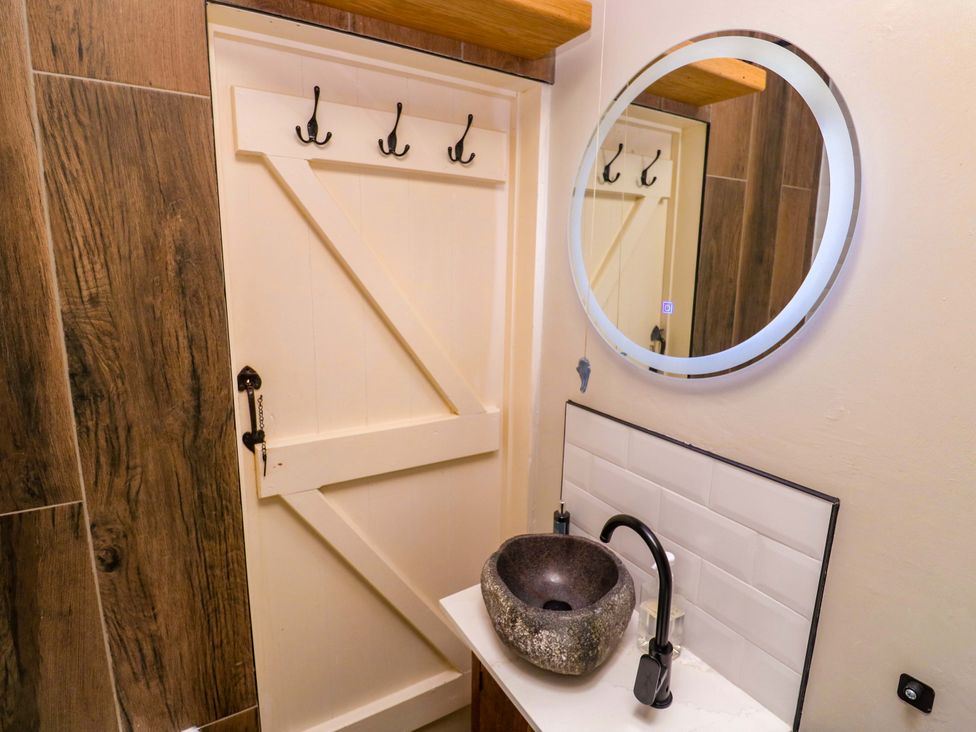 A bathroom with a sink and mirror at May Cottage Pentewan