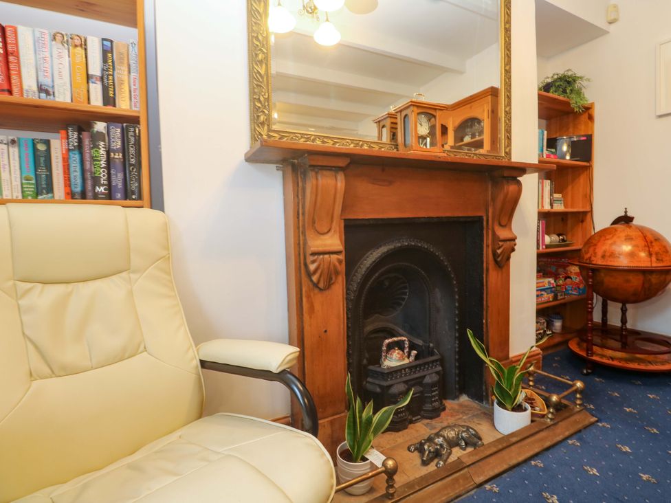 A living room with a fireplace and bookshelf at Angarrack Farmhouse in Hayle