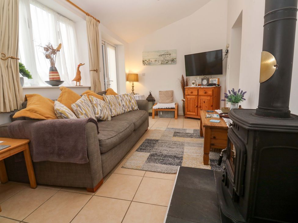 A living room with a sofa and television at Godrevy Cottage in Hayle