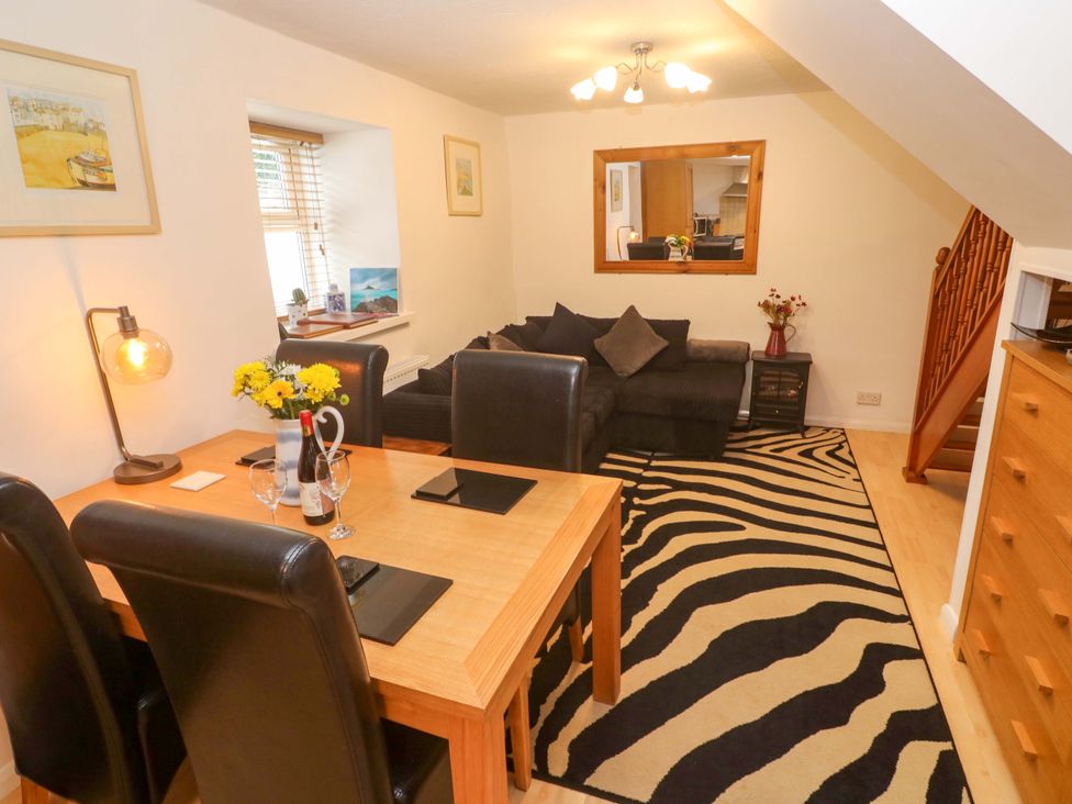 A living room with a dining area and a sofa at Godrevy Cottage in Hayle