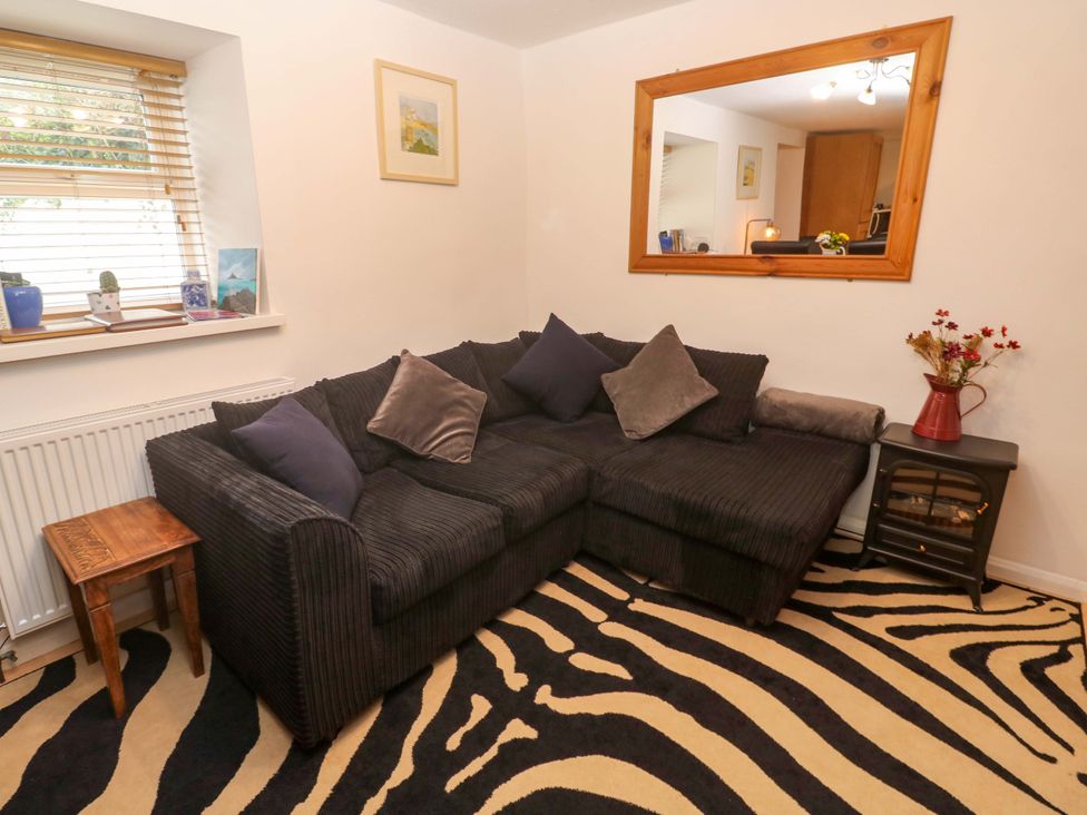 A living room with a sofa and coffee table at Godrevy Cottage in Hayle