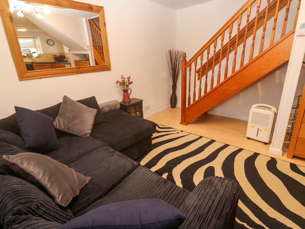 A living room with a sofa and stairs at Godrevy Cottage in Hayle