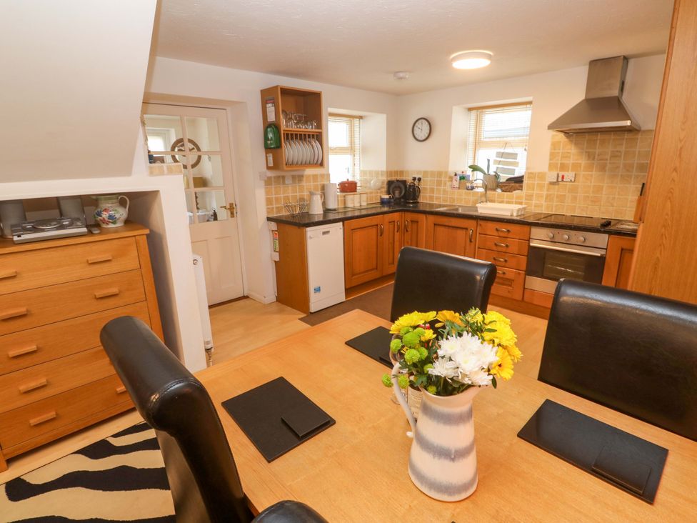A kitchen with a dining table and chairs at Godrevy Cottage in Hayle