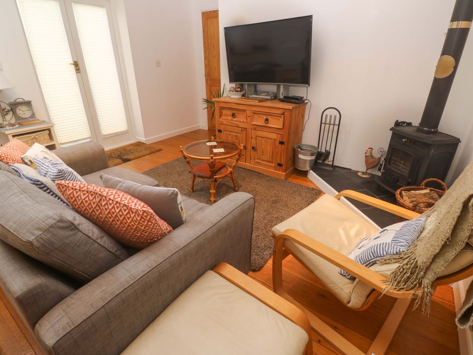 A living room with a sofa coffee table and television at Godrevy Barn in Hayle