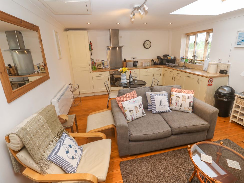 A living room with a kitchen area at Godrevy Barn in Hayle
