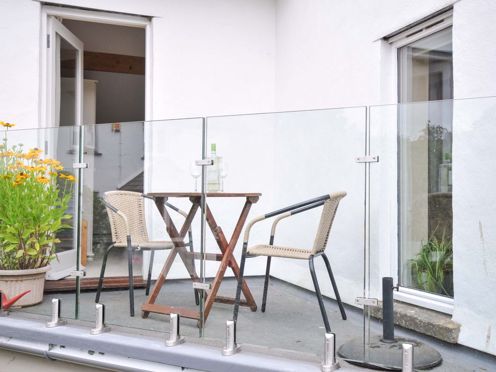 A balcony with a table and chairs at Little Hamlin in Rilla Mill Nr Callington