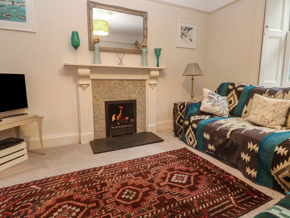 A living room with a fireplace and sofa at Banneth in Helford