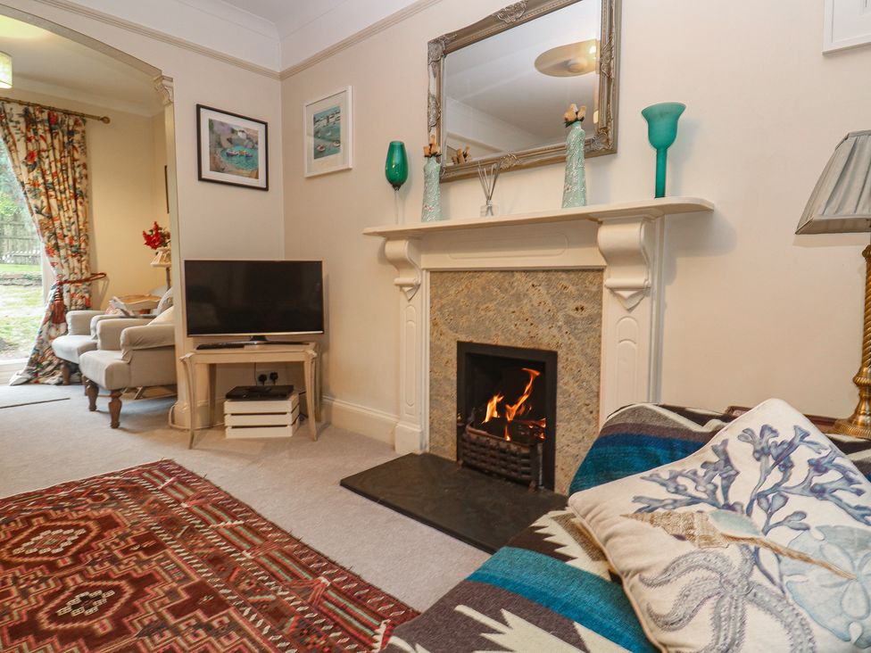A living room with a television and fireplace at Banneth in Helford