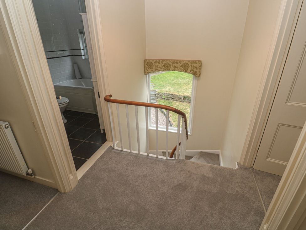 A hallway with stairs and a bathroom view at Banneth in Helford