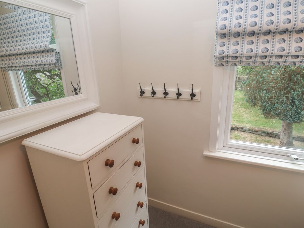 A bedroom with a chest of drawers and coat hooks at Banneth in Helford