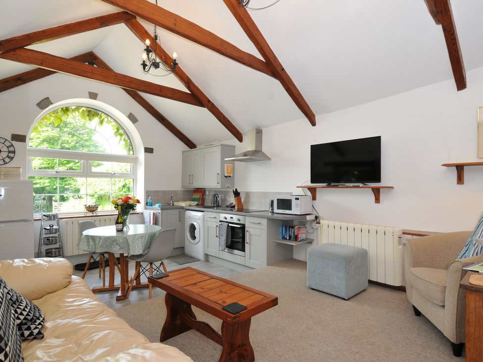A living room kitchen with appliances and furniture at Trevenning Chapel Near Port Isaac
