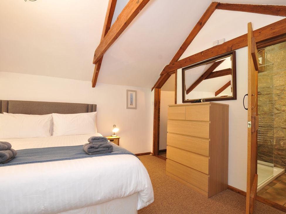 A bedroom with a bed and dresser at Trevenning Chapel Near Port Isaac