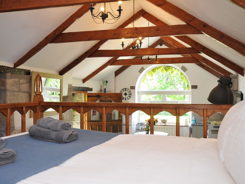 A bedroom with a bed and a view of the kitchen at Trevenning Chapel Near Port Isaac