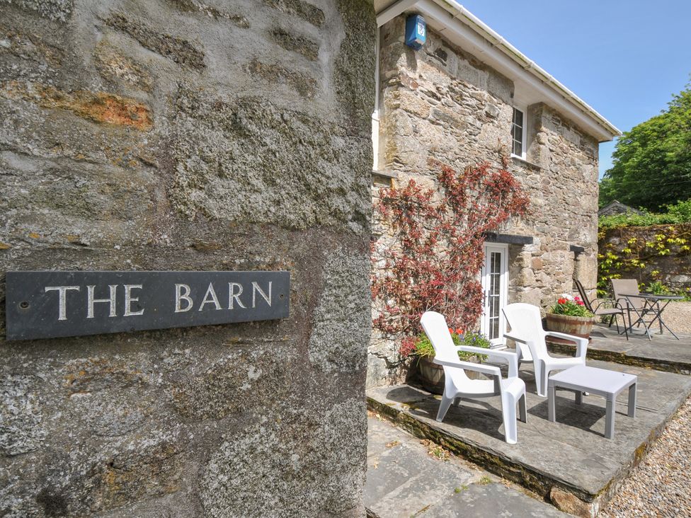 An outdoor seating area with chairs and a table at Trevenning Barn near Port Isaac