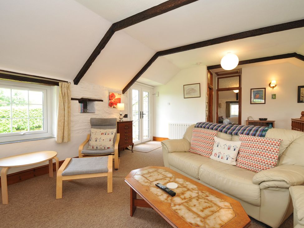 A living room with a couch and coffee table at Trevenning Barn near Port Isaac