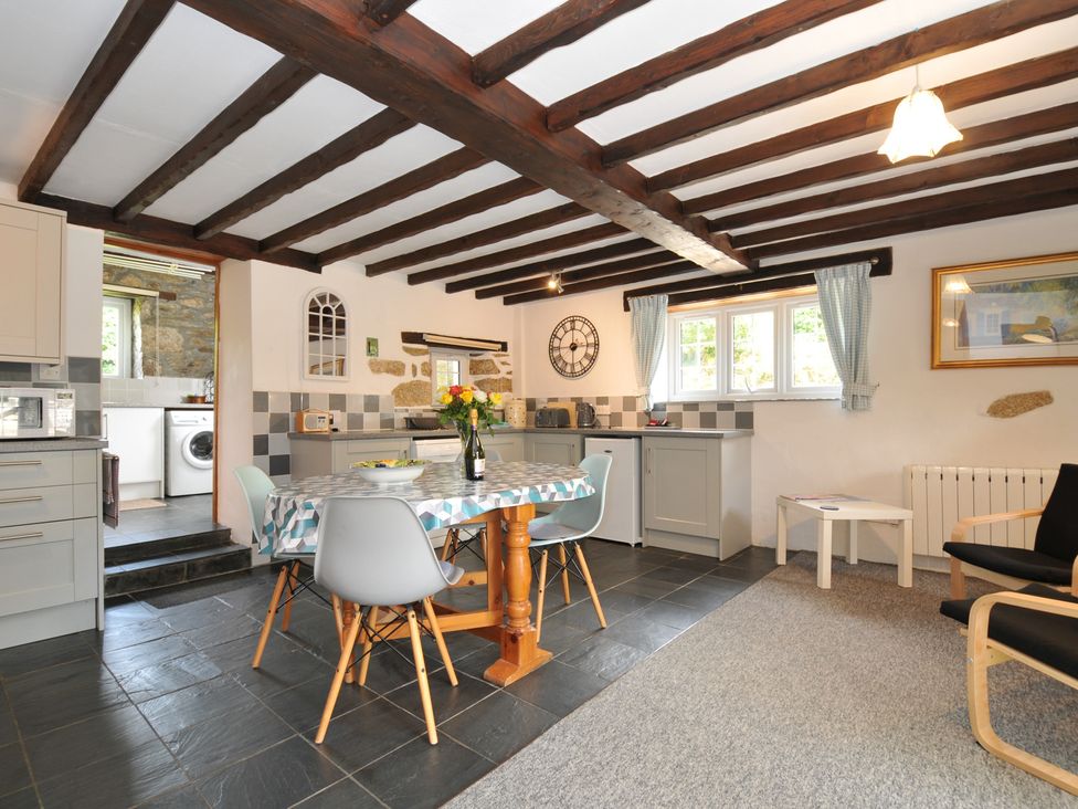 A kitchen with a dining table and chairs at Trevenning Barn Near Port Isaac