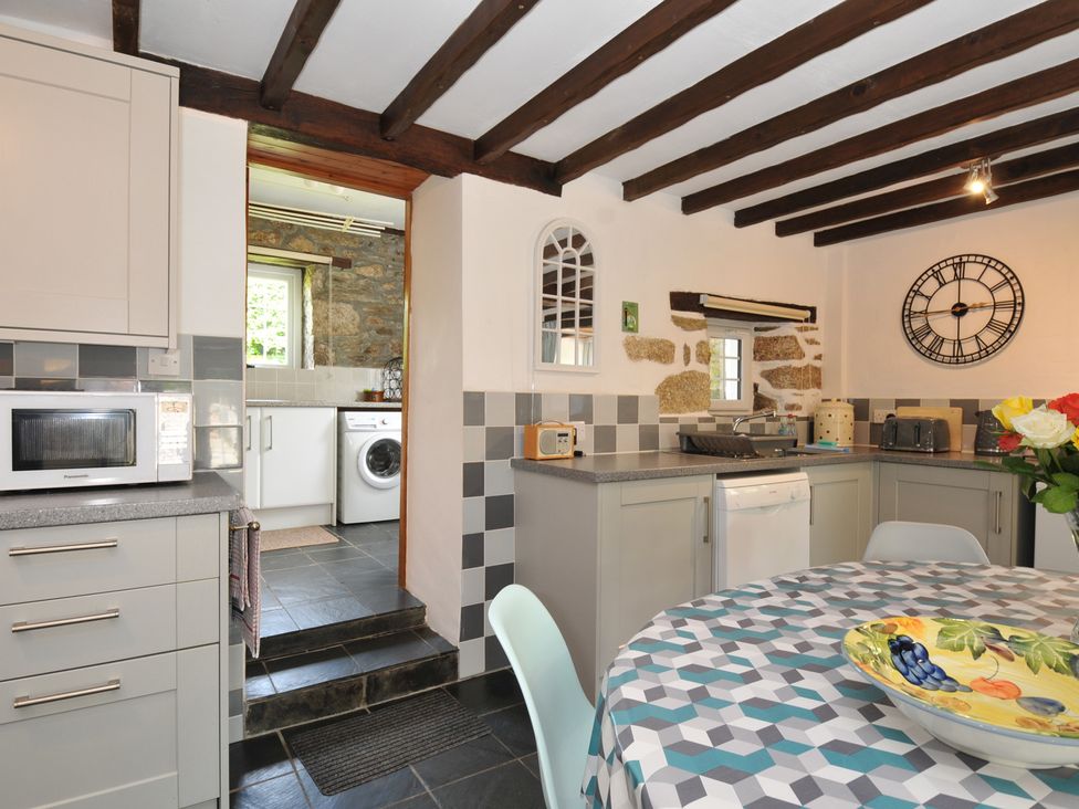 A kitchen with appliances and a table at Trevenning Barn Near Port Isaac