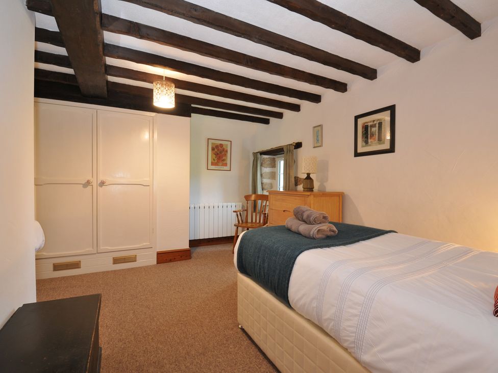 A bedroom with bed and wardrobe at Trevenning Barn Near Port Isaac