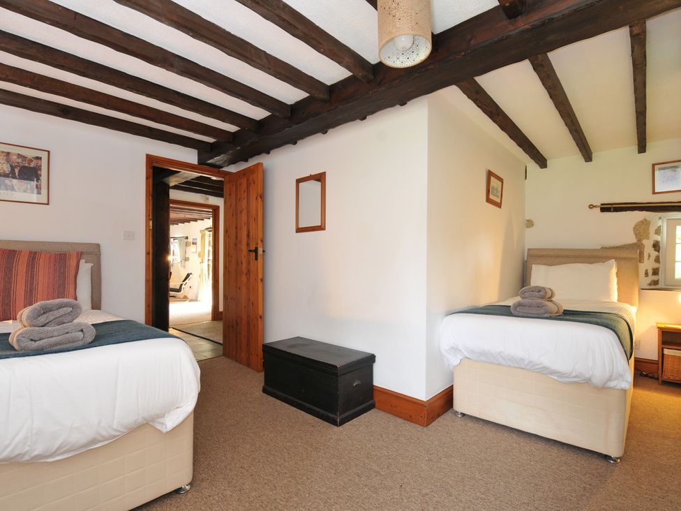 A bedroom with two beds and a chest at Trevenning Barn Near Port Isaac