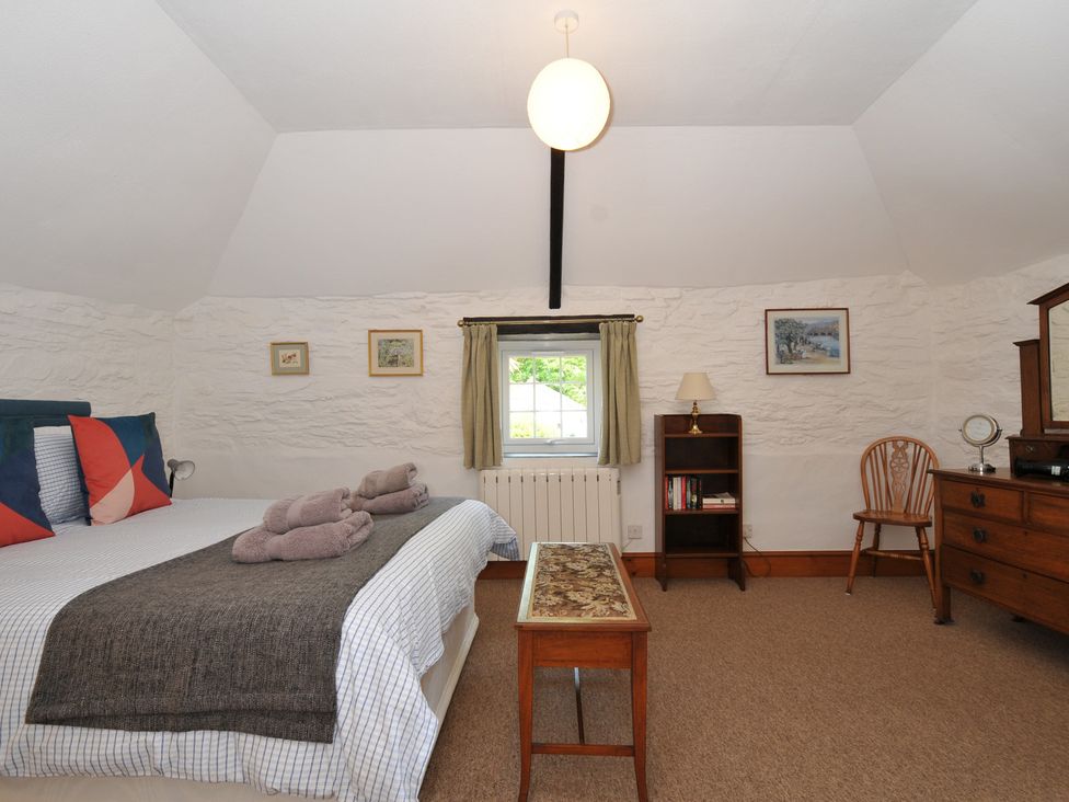 A bedroom with a bed and furniture at Trevenning Barn Near Port Isaac