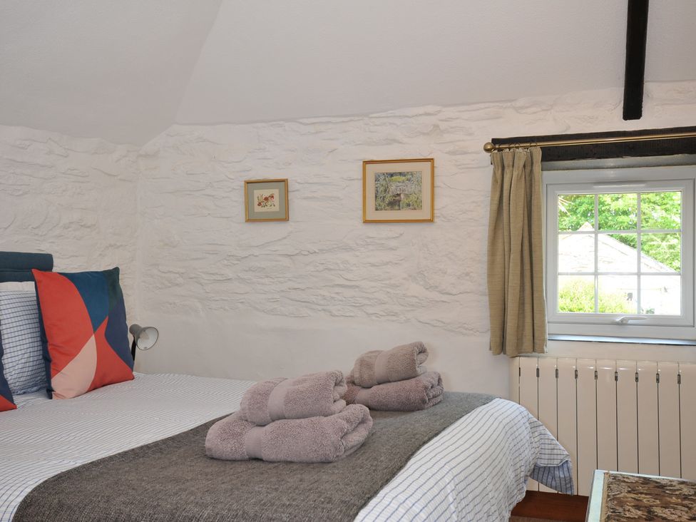 A bedroom with a bed and towels at Trevenning Barn Near Port Isaac
