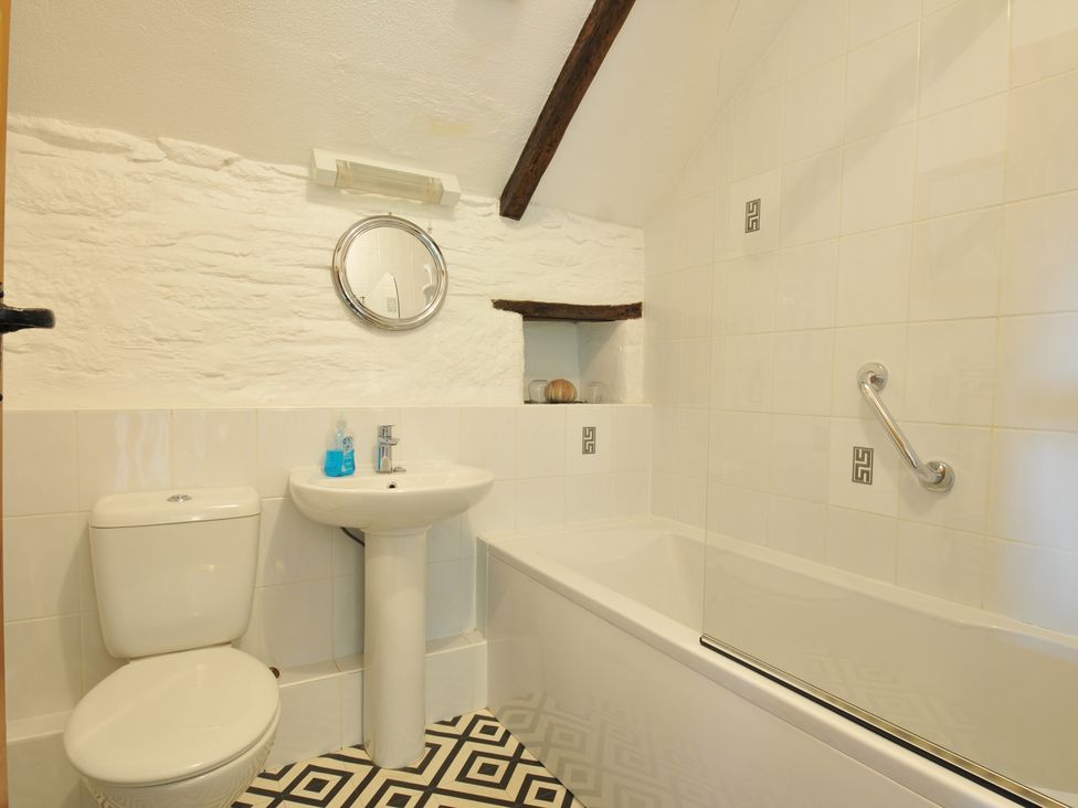 A bathroom with a toilet, sink, and bathtub at Trevenning Barn Near Port Isaac