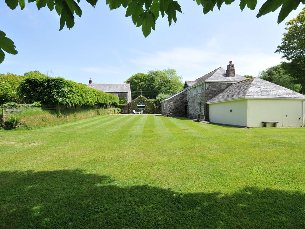A garden with grass and trees at Trevenning Barn near Port Isaac