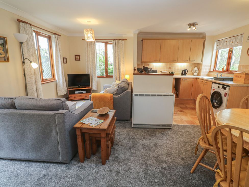 A living room with a sofa and television in Two Hoots Falmouth