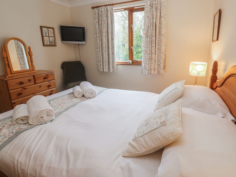 A bedroom with a bed and dresser at Two Hoots in Falmouth