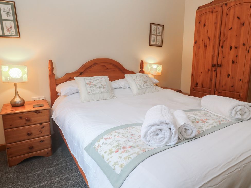 A bedroom with a double bed and wardrobe at Two Hoots in Falmouth