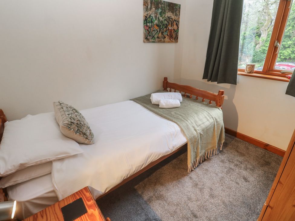 A bedroom with a single bed and artwork at Two Hoots in Falmouth