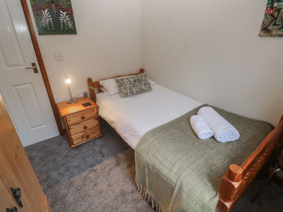 A bedroom with a single bed and bedside table at Two Hoots in Falmouth
