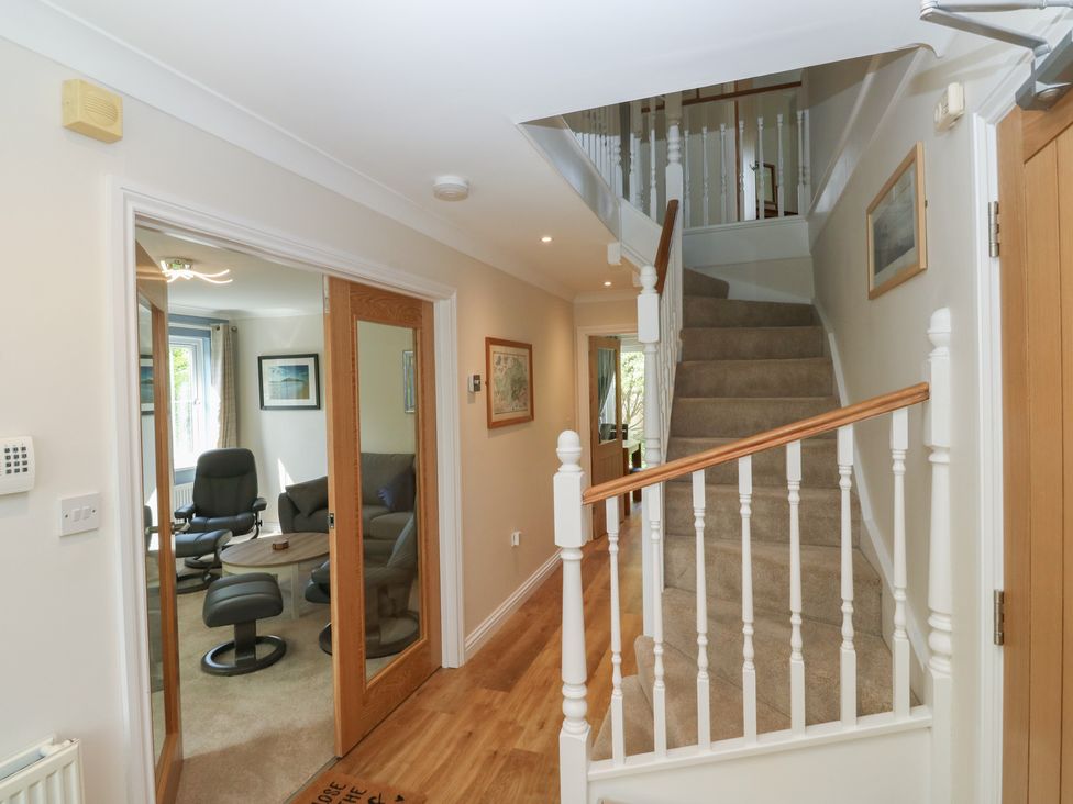 A hallway with a staircase and doors at Glebe House Bigbury