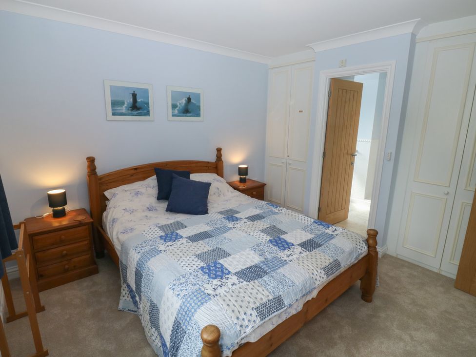 A bedroom with a bed and wardrobe at Glebe House in Bigbury