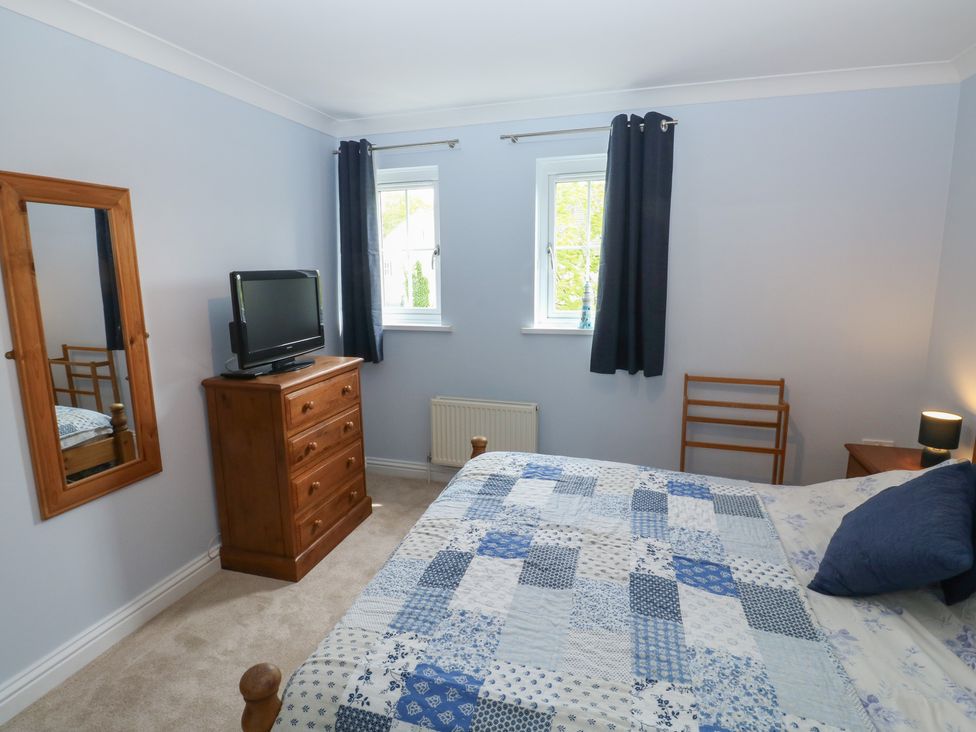 A bedroom with a bed and television at Glebe House in Bigbury