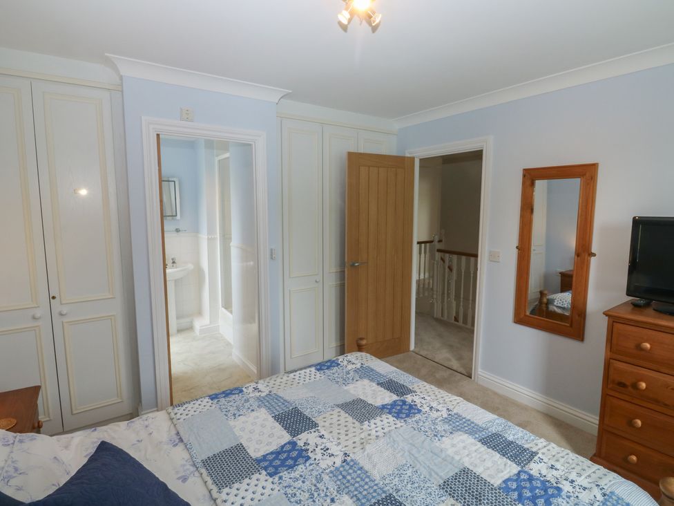 A bedroom with a bed and wardrobe at Glebe House in Bigbury