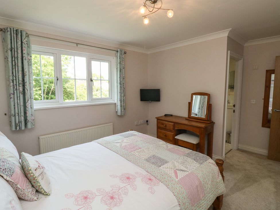 A bedroom with a bed and dresser at Glebe House in Bigbury
