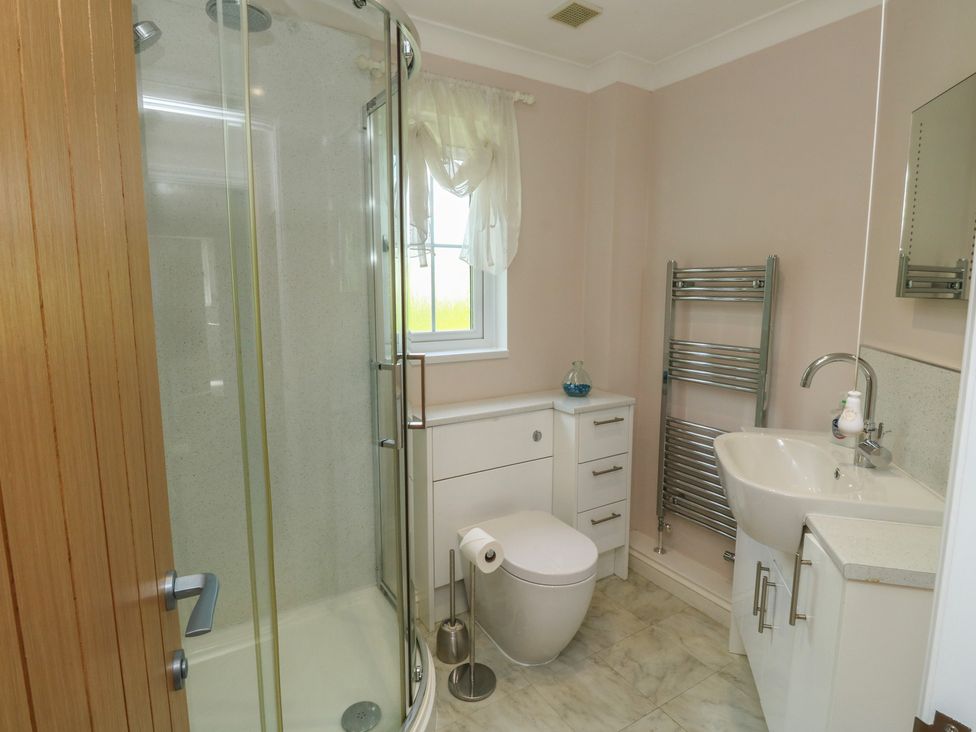 A bathroom with a shower, toilet, and sink at Glebe House in Bigbury