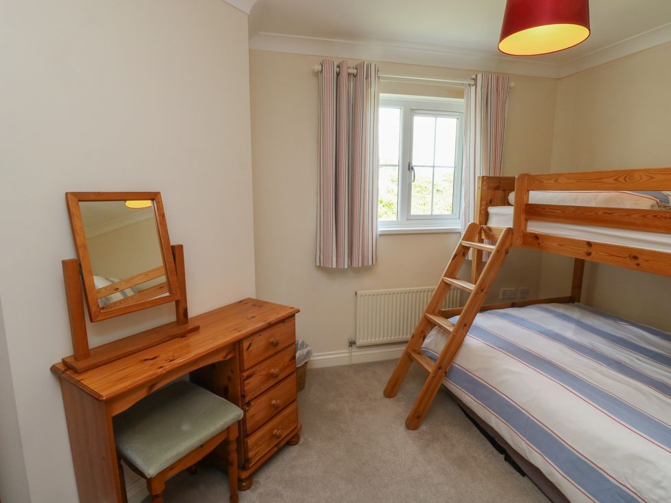 A bedroom with a bunk bed and dressing table at Glebe House in Bigbury