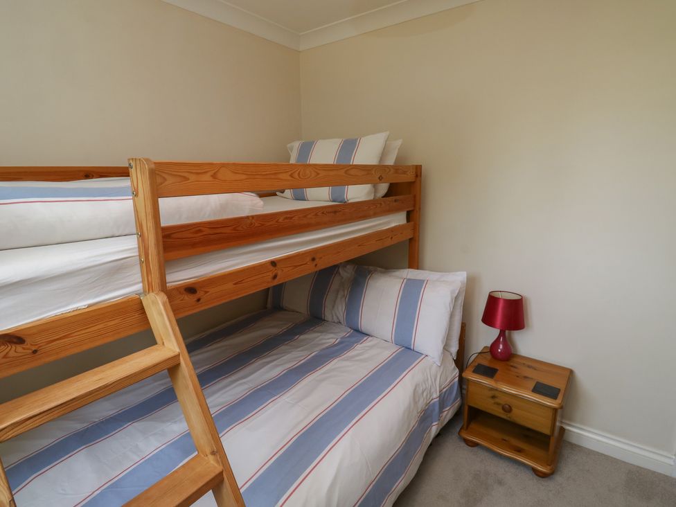 A bedroom with a bunk bed and bedside table at Glebe House in Bigbury
