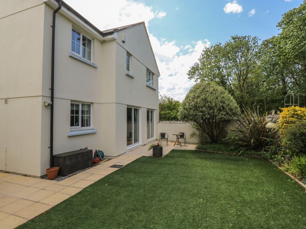 A garden with chairs and a house at Glebe House in Bigbury