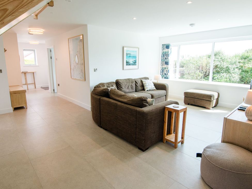 A living room with a sofa, table, and lamp at Lanesend in St Agnes