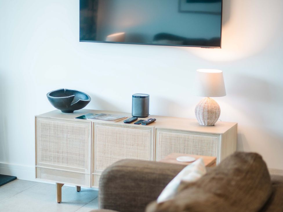 A living room featuring a television and wireless speaker at Lanesend in St Agnes
