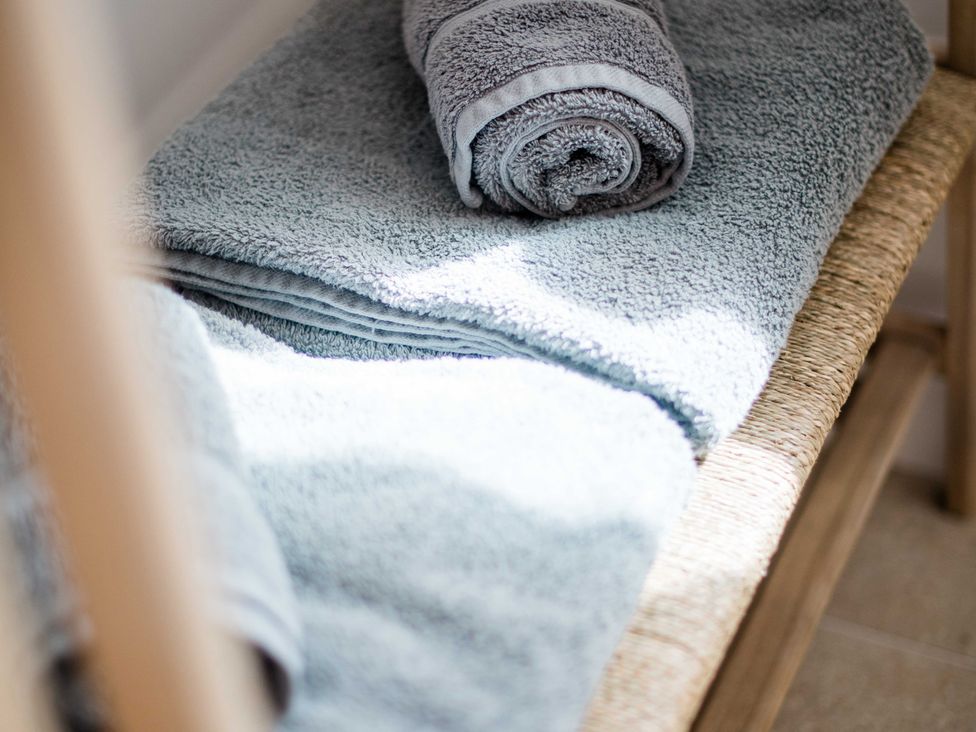 A shelf with folded and rolled towels at Lanesend in St Agnes