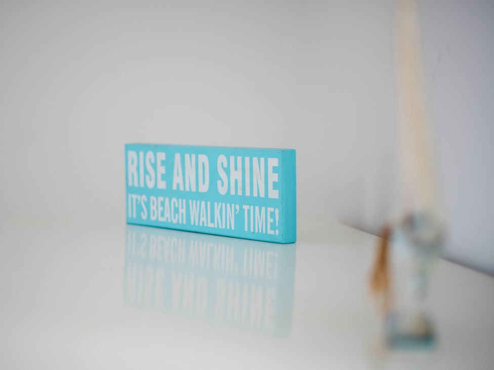 A sign with the text 'Rise and shine it's beach walkin' time' at Lanesend in St Agnes