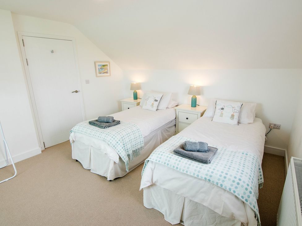 A bedroom with two single beds and a nightstand at Lanesend in St Agnes