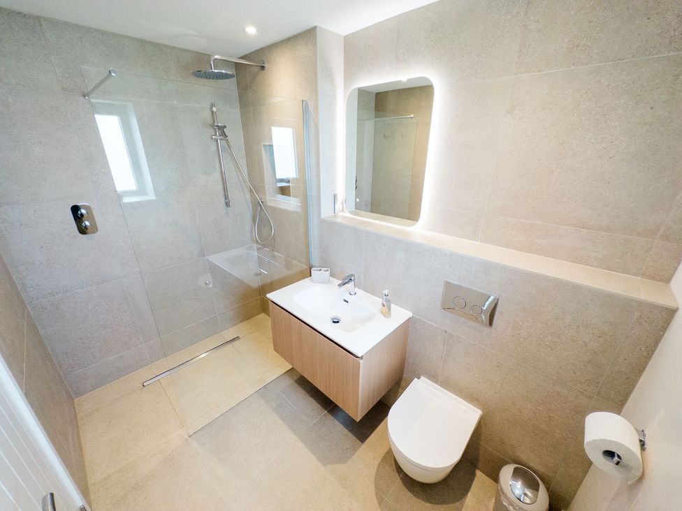 A bathroom featuring a shower, sink, and toilet at Lanesend, St Agnes