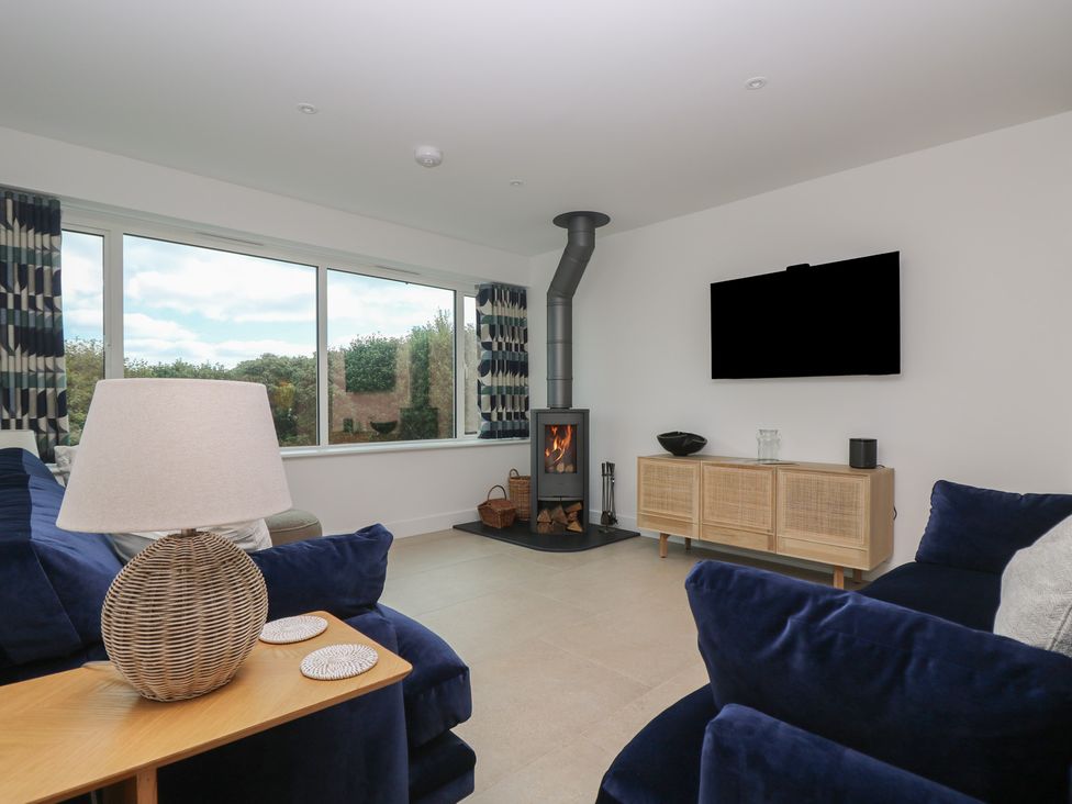 A living room with a fireplace and television at Lanesend in St Agnes