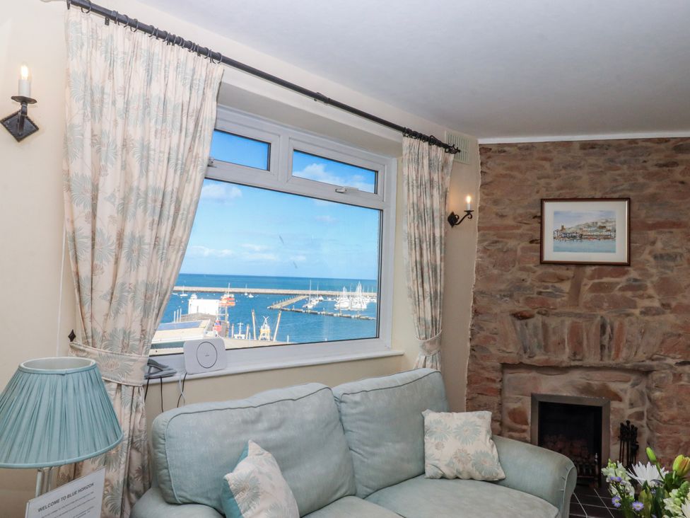 A living room with a window overlooking the harbor at Blue Horizon in Brixham