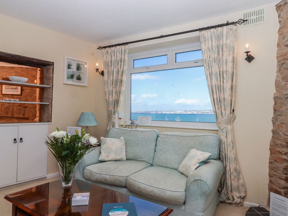 A living room with a sofa and window at Blue Horizon in Brixham